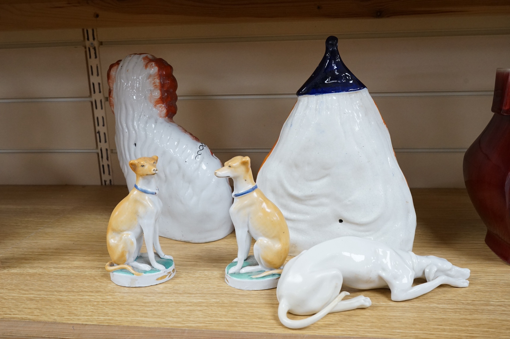 Four Victorian Staffordshire models, to include a pair of dogs, and a Nymphenburg whippet, largest 25cm high. Condition - fair/good